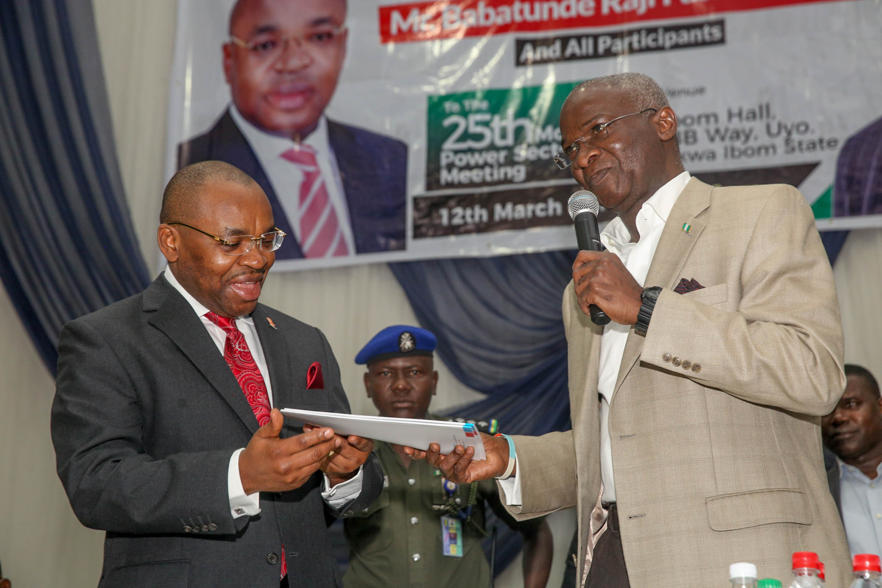 Babatunde Fashola, minister of power, works & housing, (right), presenting a copy of the Meter Asset Provider Regulations 2018 to Udom Emmanuel, the Governor of Akwa 