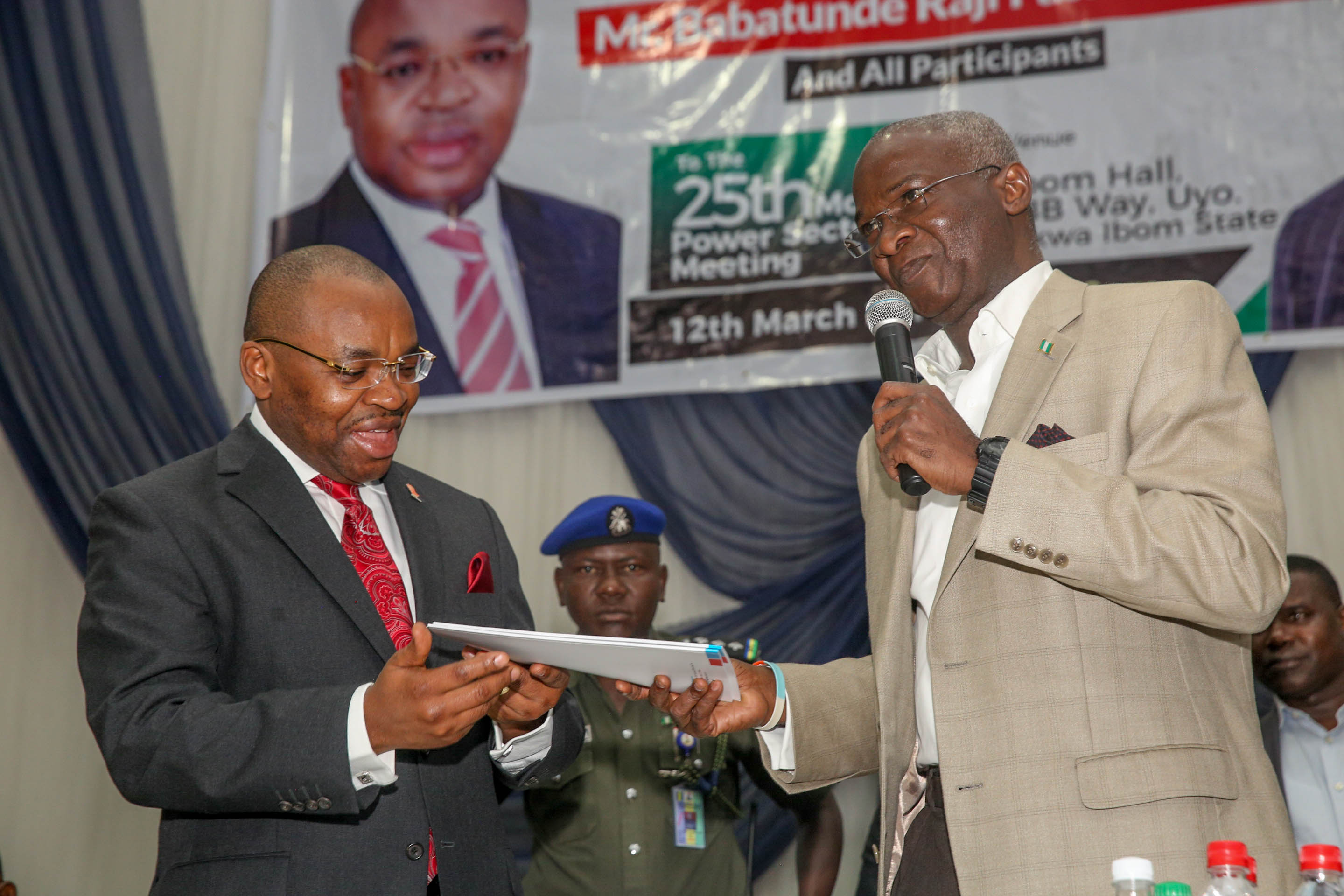Babatunde Fashola, minister of power, works & housing, (right), presenting a copy of the Meter Asset Provider Regulations 2018 to Udom Emmanuel, the Governor of Akwa